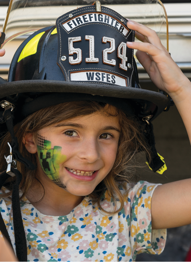 young girl wearing firefighter helmet
